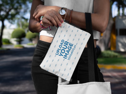 Mockup of a Young Woman Carrying a Cosmetic Pouch on the Street