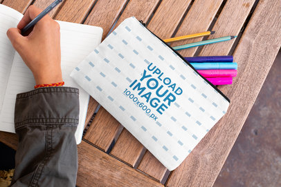 Pouch Mockup of a Woman Writing in a Notebook