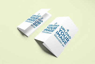 Mockup Featuring Two Trifold Brochures Lying Against a Plain Backdrop