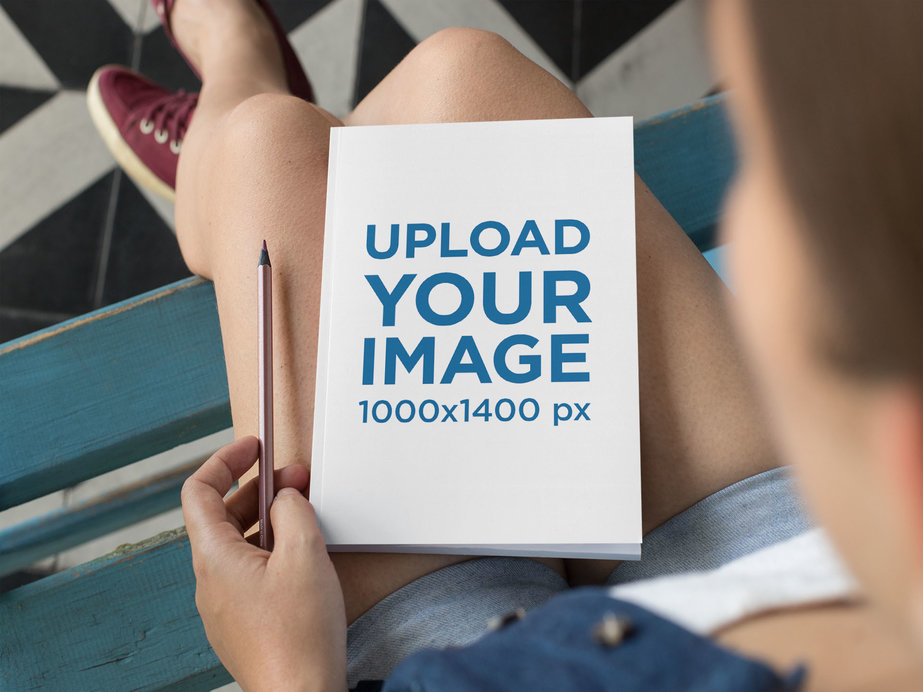 Mockup of a Woman with an A5 Notebook over Her Lap
