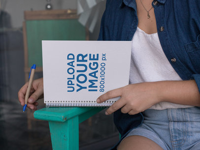 Mockup of a Woman Writing in a Spiral Notebook