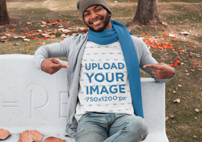 T-Shirt Mockup Featuring a Man Sitting on a Concrete Bench at a Park in Autumn 