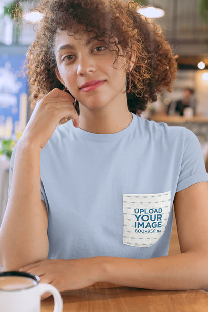 Pocket Mockup of a Woman Wearing a T-Shirt at a Cafe