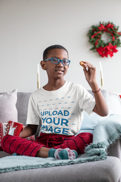 T-Shirt Mockup Featuring a Kid with Glasses at a Xmas Decorated Living Room