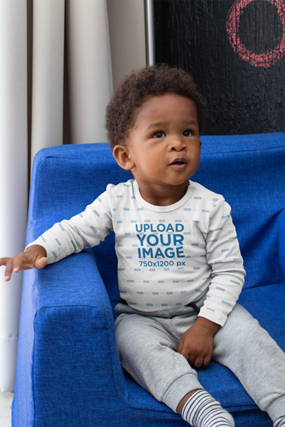 Long Sleeve Onesie Mockup of a Baby Boy Sitting on a Couch