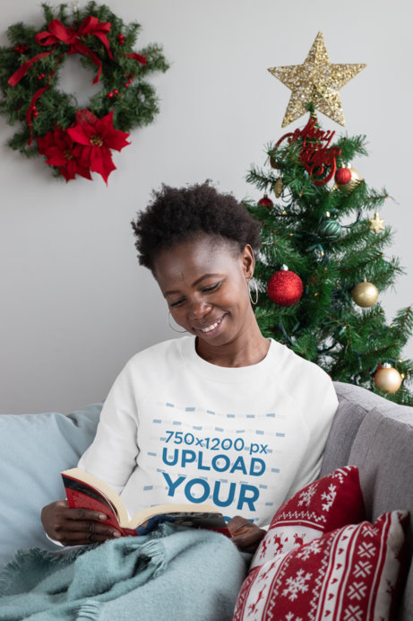 Sweatshirt Mockup of a Happy Woman Reading Next to a Christmas Tree