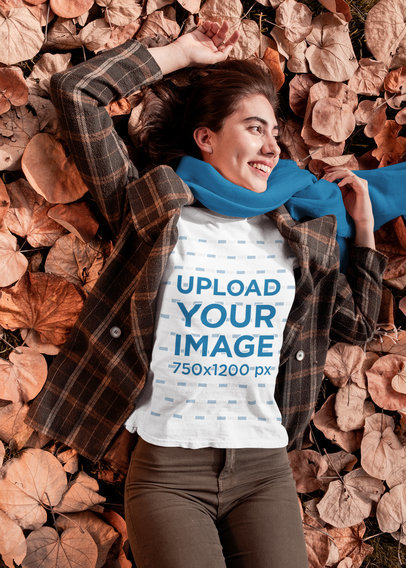 T-Shirt Mockup of a Woman Lying on Autumn Leaves