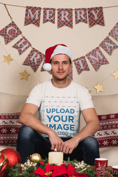 T-Shirt Mockup of a Man Wearing a Christmas Hat at Home