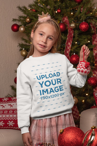 Sweatshirt Mockup Featuring a Little Girl by a Christmas Tree
