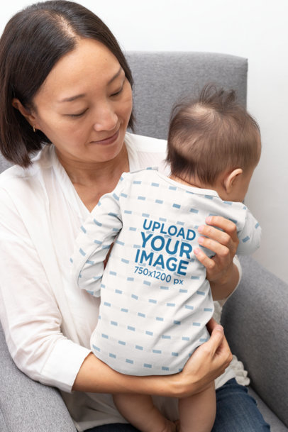 Mockup of a Baby Wearing a Sublimated Onesie in His Mom's Arms