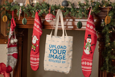 Mockup of a Tote Bag Hanging Between Christmas Stockings
