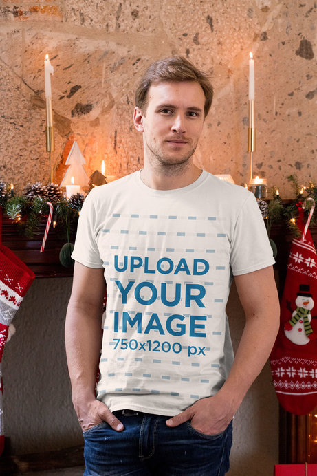 T-Shirt Mockup of a Man in a Cozy Christmas Setting with Candles