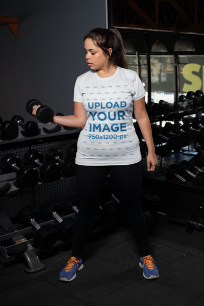 Plus Size T-Shirt Mockup of a Woman Lifting Dumbbells at the Gym