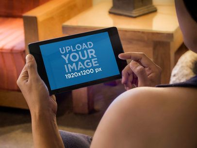 Over-the-Shoulder Mockup of a Woman Holding Nexus 7 in Landscape Position