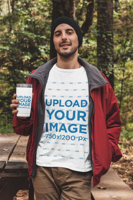 T-Shirt Mockup Featuring a Man Holding a 20 oz Travel Mug in the Woods 