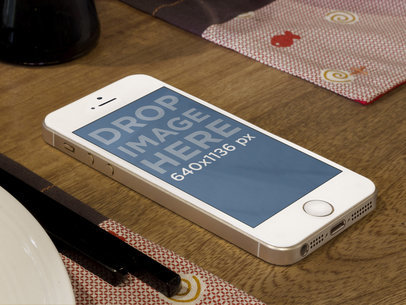 Mockups of an iPhone Lying on a Restaurant Table