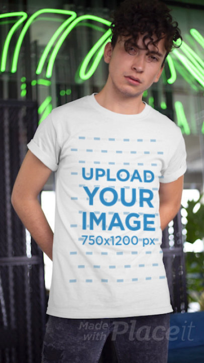 T-Shirt Video Featuring a Young Man Posing by Some Neon Light Reflections 