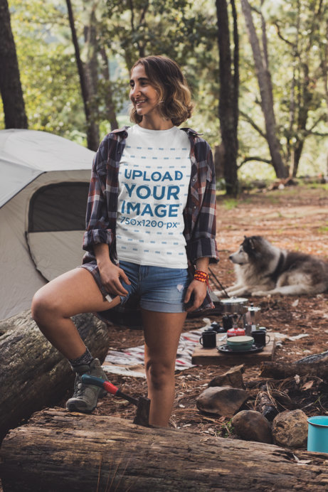 Mockup of a Young Woman at a Campfire Wearing a Customizable T-Shirt 