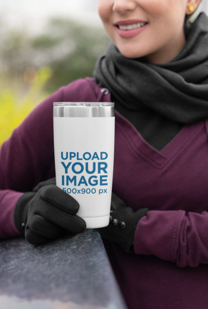 Mockup of a Woman in Winter Clothing Holding a 20 oz Travel Mug 
