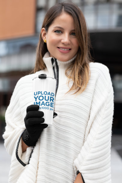 Mockup of a Woman Holding a 20 oz Travel Mug at a Winter Setting 30426
