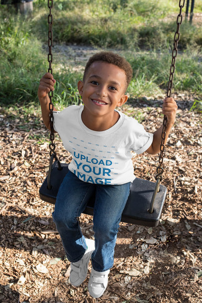 T-Shirt Mockup of a Smiling Boy Playing on a Swing