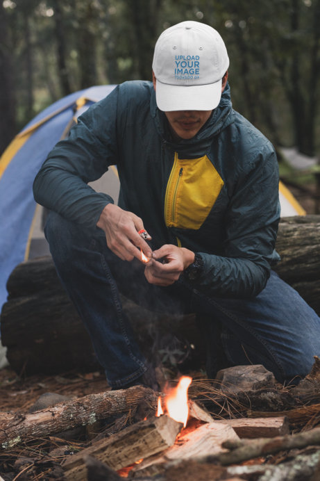 Mockup of a Man with a Dad Hat Lighting a Fire