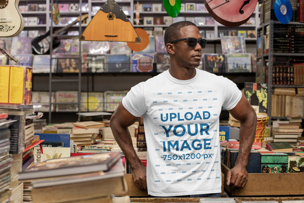 T-Shirt Mockup Featuring a Man with Sunglasses at a Vintage Records Store