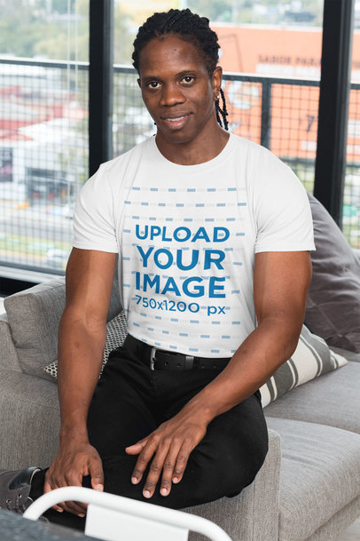 T-Shirt Mockup of a Muscular Man in a Living Room