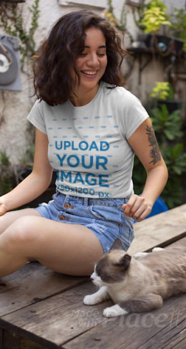 T-Shirt Video of a Woman with an Arm Tattoo Sitting Next to a Cat 