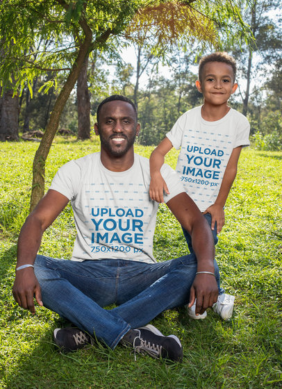 T-Shirt Mockup of a Man Sitting at the Park with His Kid