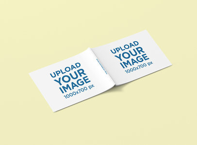 Mockup of an Open Horizontal Magazine Lying on a Solid Color Surface 