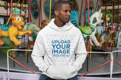 Mockup of a Man Wearing a Pullover Hoodie at a Carousel