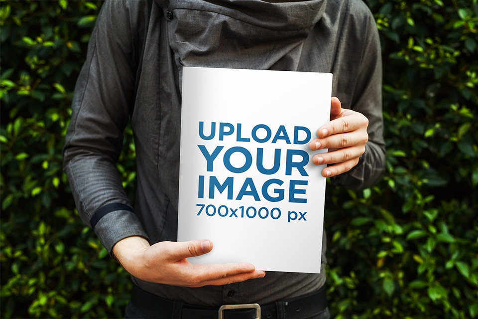 Mockup of a Man Showing the Cover of a Magazine