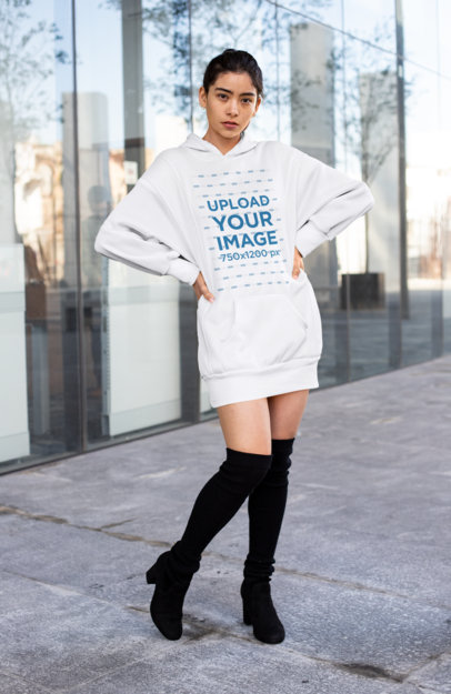 Mockup of a Woman with a Hoodie Dress Posing in Front of a Glass Building