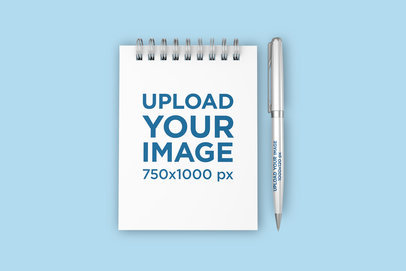 Mockup of a Small Spiral Notebook and a Pen Against a Minimalistic Surface