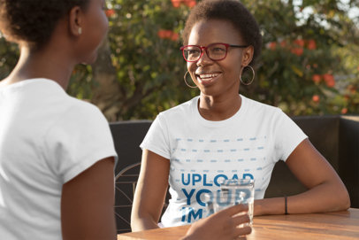 T-Shirt Mockup Featuring a Mother and Daughter Talking at a Table