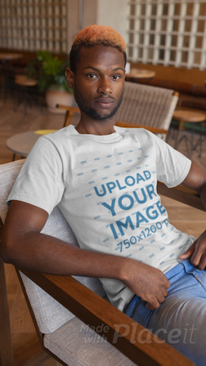 T-Shirt Video of a Young Man Sitting on a Modern Chair 22538
