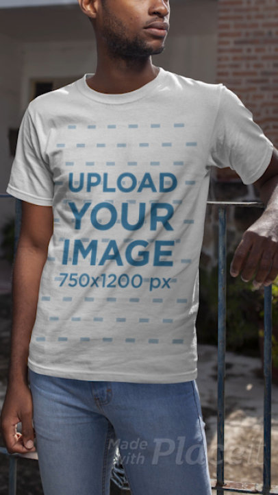 T-Shirt Video of a Young Man Leaning Against a Metal Fence 