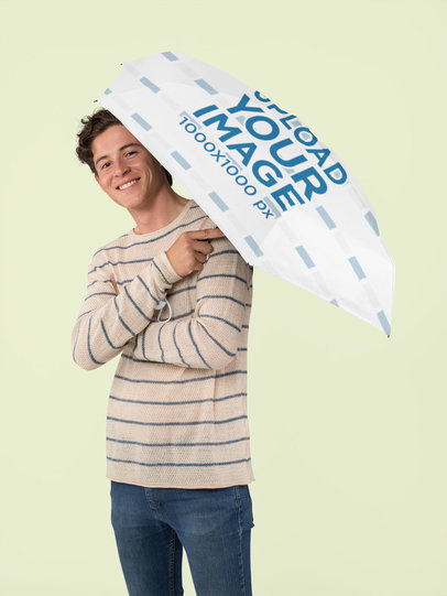Mockup of a Smiling Man Holding an Umbrella at a Studio