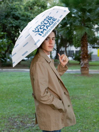 Mockup of a Stylish Man Holding an Umbrella by a Park