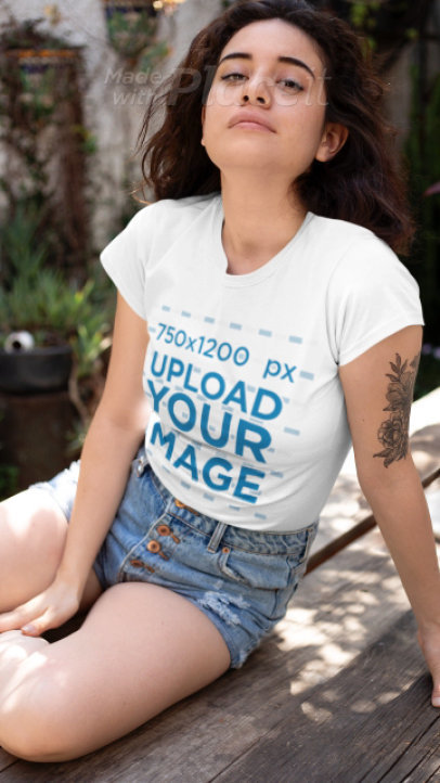 T-Shirt Video of a Young Tattooed Woman Sitting on a Wooden Garden Table 