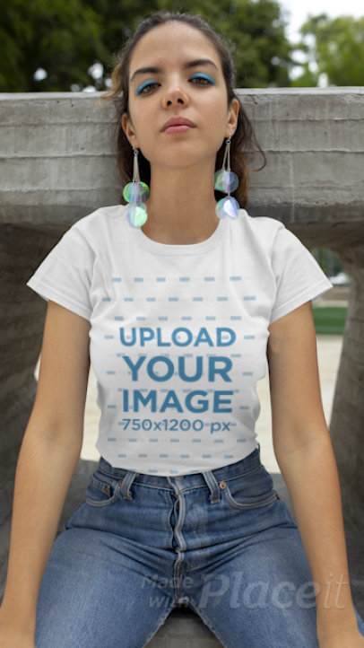 T-Shirt Video Featuring a Young Woman Sitting on a Concrete Structure 