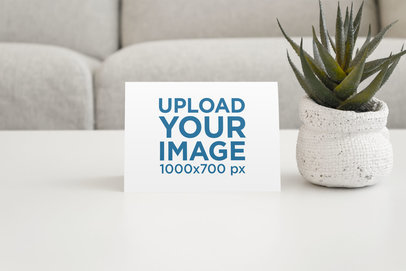 Mockup of a Postcard on a Living Room Table with a Desert Plant 946-el