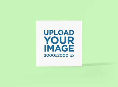 Mockup of a Square Booklet Standing Against a Plain Color Backdrop