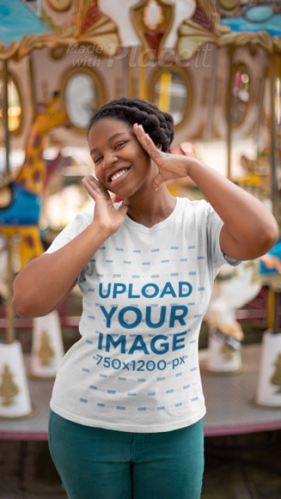 T-Shirt Video Featuring a Joyful Woman Posing by a Carousel