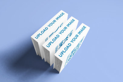 Mockup Featuring Three Square Hardcover Books Standing on a Solid Color Surface