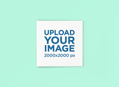 Mockup Featuring a Closed Square Booklet Placed on a Colored Surface 