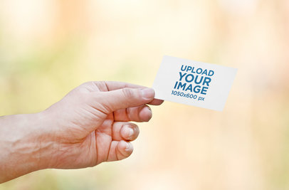 Mockup of a Man Holding a Business Card