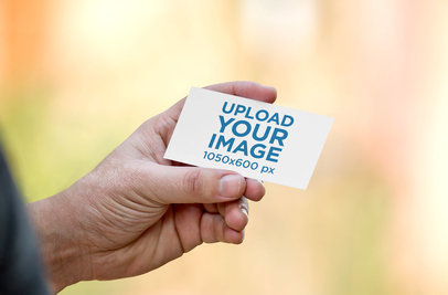 Mockup of a Man's Hand Holding a Business Card 