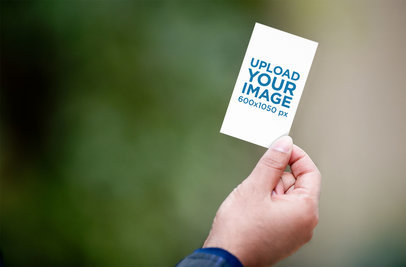 Mockup of a Hand Holding a Vertical Business Card by the Corner 1651-el